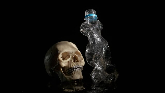 A crumpled plastic bottle and a human skull. The concept of death from plastic pasuda.