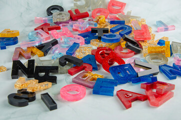 Acrylic letters, acrylic letters scattered randomly on light surface, selective focus.