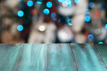 Rustic painted green table with beautiful blurred Christmas tree lights and bokeh in the background Christmas. 