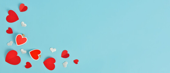 Paper hearts on light blue background with space for text. Valentine's Day celebration