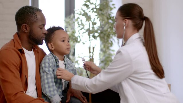 Loving black father guiding his son in art of money management, adorable little boy putting coin into piggy bank