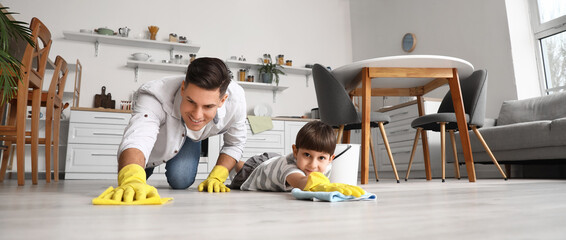 Father and son cleaning floor in kitchen