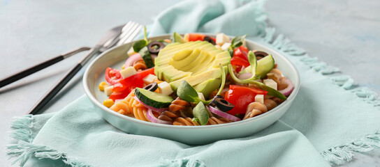 Plate with tasty pasta salad on table