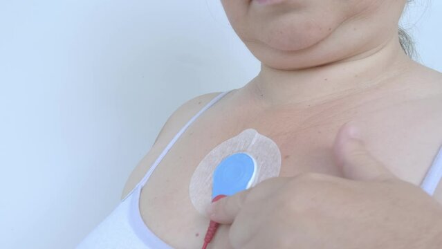 electronic sensor on female chest for Holter monitoring, track pacemaker dysfunction, daily monitoring of electrocardiogram, blood pressure, cardiac examination, treatment of cardiac diseases
