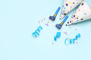 Composition with party hats, whistles and confetti on color background