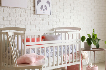 Baby crib in interior of light bedroom
