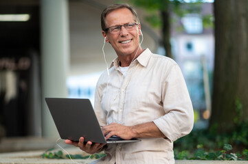 Fototapeta premium Man working online with laptop computer outdoor.