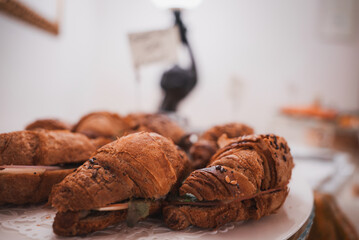 Freshly baked croissants on a plate in a cozy bakery in Venice, Italy. The inviting atmosphere and delicious pastries make this a must-visit spot for travelers.