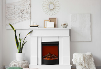 Stylish fireplace near light wall