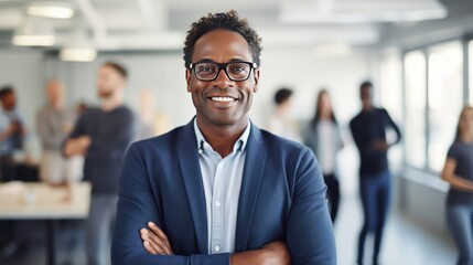 Portrait of confident businessman, dark skin, short hair, glasses at creative office with colleagues discussing
