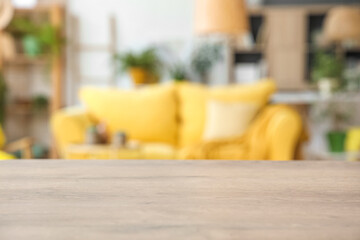 Blurred view of modern living room with yellow sofa and houseplants