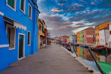 Scenic view of colorful buildings along a waterway in Burano, Italy. Reflections of the buildings...