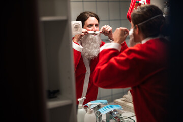 Confident Mid Adult Woman Prepares Herself into a Costume of Santa Claus in front of the mirror for...