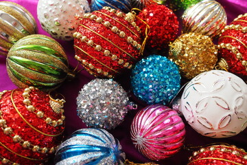 Fototapeta na wymiar Colourful glass shiny balls. New Year's Christmas decoration. Festive design. Red, blue, golden, white, green striped balls. Christmas and New years eve Background. Close up of Christmas ornaments.