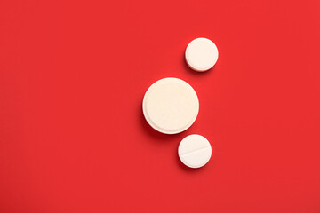 Medical pills on red background