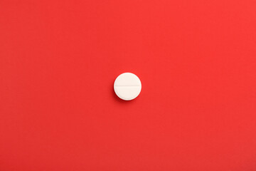 Medical pill on red background
