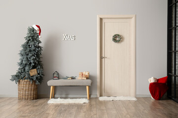 Interior of living room with soft bench, door and Christmas tree