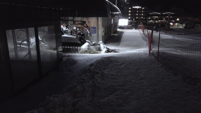 snowcat vehicle during night skiing at winter ski resort.