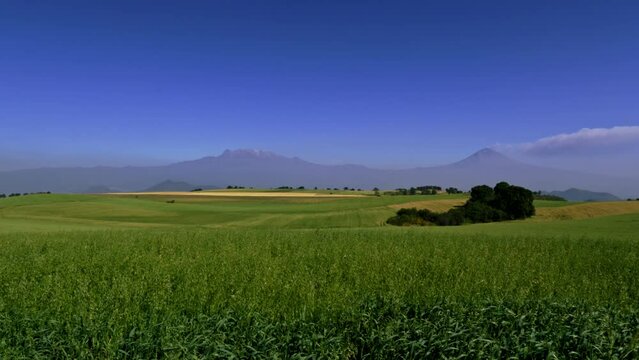 View of the Popocatepetl volcanoes launching fumarole and Iztaccihuatl from the countryside south of Mexico City.
