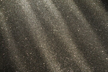 Oblique rays of light on a black surface. Bokeh, dust particles, reflection and magical glow....