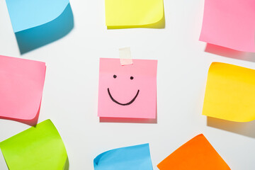 Emoji with a cheerful emotion, smile icon on sticky notes