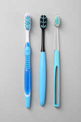 Many different toothbrushes on light background, flat lay