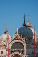 Fototapeta na wymiar Ornate Gothic cathedral in Venice, Italy, with stunning architectural details and towering spires against a blue sky. A standout landmark in the city.