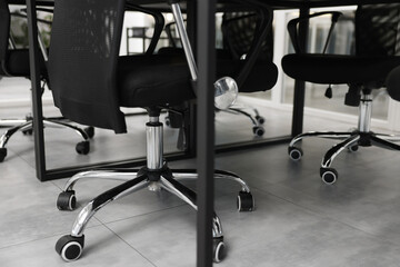 Comfortable office chairs and tables in meeting room, closeup