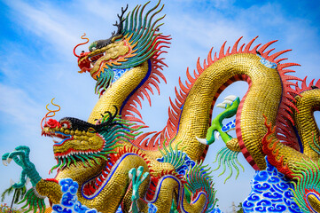 Golden dragon statue with blue sky