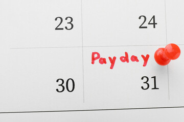 Calendar page with red pin on payday date, top view