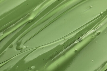 Clear cosmetic gel on light green background, closeup