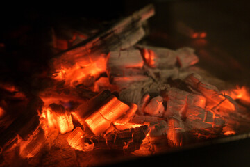 A glowing camp fire providing comfortable lights and barbecue grill pit with glowing and flaming of...