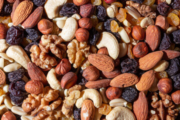 Mixed Nuts: Almonds, Walnuts, Cashews, Peanuts, Hazelnuts, Dried Prunes and Raisins. Different Nut Mix. Background from Various Nuts and Dried Fruits
