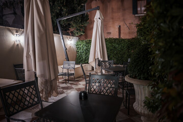 Experience a romantic and relaxing evening at an outdoor seating area in Venice, Italy. Enjoy dim lighting and soft music in this luxurious and elegant ambiance.