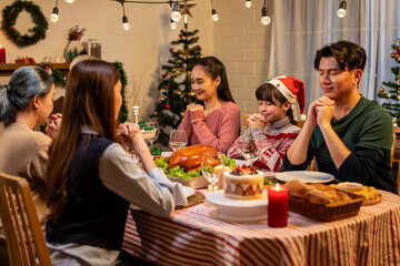 Asian lovely family say a prayer before celebrate Christmas dinner party.