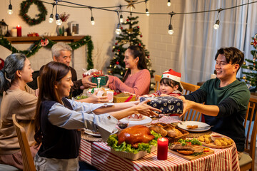 Asian lovely family exchanging presents during Christmas party at home.