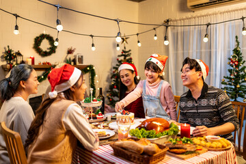 Asian lovely family celebrating Christmas party together in house.