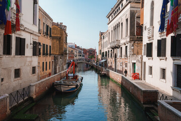 Fototapeta na wymiar Scenic narrow canal in Venice, Italy with traditional architecture and boats. Serene waterway with no landmarks visible. Ideal for travel, tourism, and vacation concepts.
