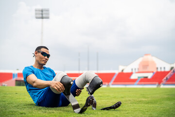 Asian para-athlete with prosthetic blades stretching leg in stadium. 
