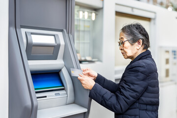 銀行のATMの操作をしようとする高齢者の女性