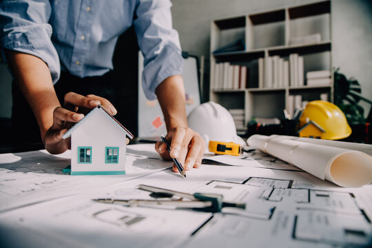 architect man working with laptop and blueprints,engineer inspection in workplace for architectural plan,sketching a construction project ,selective focus,Business concept vintage color