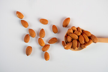 Almonds seed on spoon wooden on white background