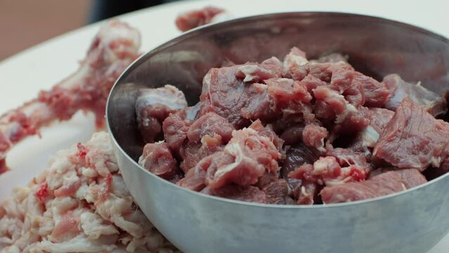 Raw mutton in metall bowl close-up. Muttons meat for uzbek pilaf. Turkey food. Chef preparing a bif piece of fresh raw meat 