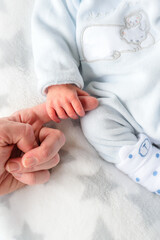 Hand of a newborn with white clothes
