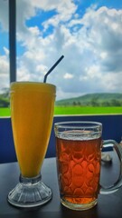 juice mango and cup of tea on the background of blue sky