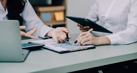 Entrepreneur Asian businessman and businesswoman discussing new business project in tablet in...