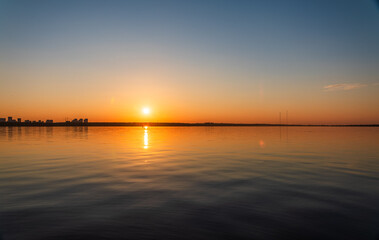 Obraz premium Lake with pine and birch forest on the shores at summer or early autumn sunset.