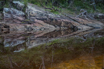 Fototapeta na wymiar Rock layers reflected on a pond