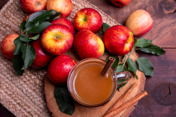 Autumn warm drink. Apple cider in glass cup on wood background with. Top view