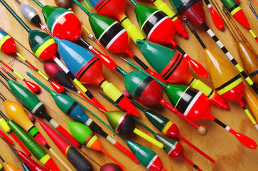 Multicolored fishing floats on a wooden texture background. © yrafoto